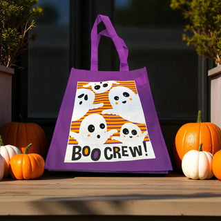 Purple Halloween tote bag with ghost design and 'BOO CREW!' text, surrounded by pumpkins on a wooden surface.