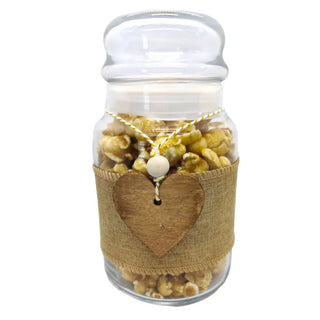 Glass jar filled with popcorn and a heart-shaped tag on a white background
