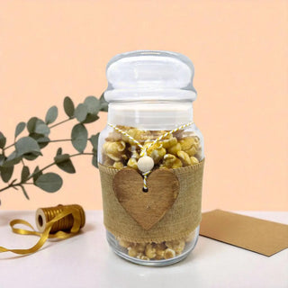 Glass jar with popcorn and a heart-shaped tag on a light background