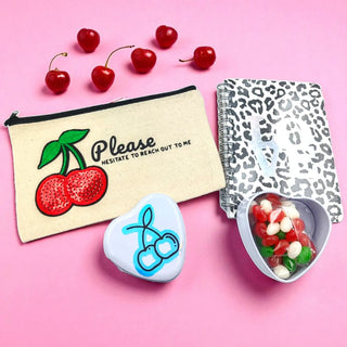 Cherry on Top gift bundle with cherry-themed accessories and gourmet snacks on a pink background