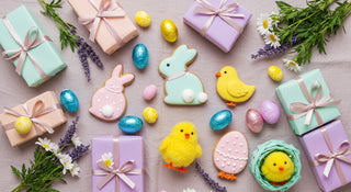 Easter-themed cookies and gift boxes on a wooden surface with flowers and eggs.