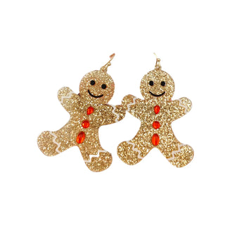 Gold glitter gingerbread man earrings with red buttons on a white background
