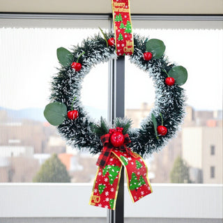 Christmas wreath with red berries and a plaid ribbon on a white background