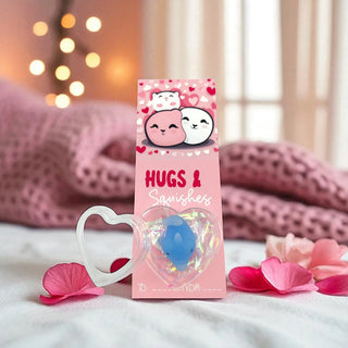 Product packaging with 'Hugs & Squishies' branding on a soft background with pink petals.