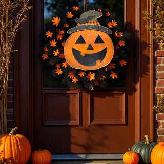 Halloween wreath with jack-o'-lantern design on a door, surrounded by pumpkins.