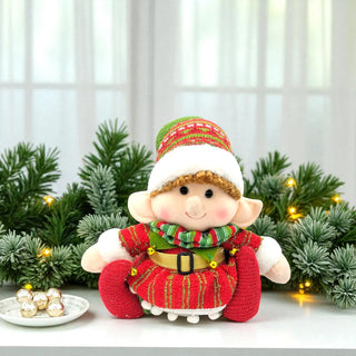 Decorative elf figurine with a festive outfit in front of Christmas decorations.