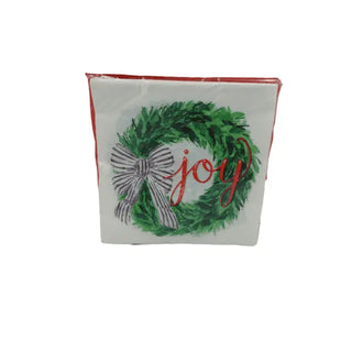 white serviette with green wreath adorned with a black-and-white bow and the word "joy"