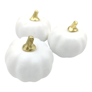 Three white pumpkins with gold stems on a white background