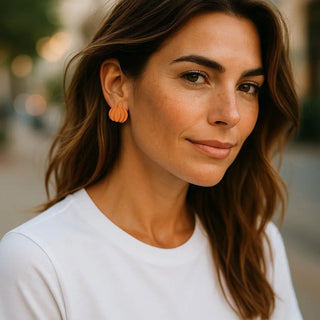 Woman wearing orange earrings with a blurred background