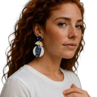 Woman wearing large earrings with a white background