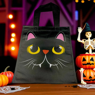 Black cat-themed Halloween tote bag with pumpkins and skeleton in the background