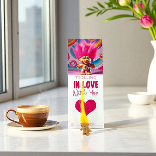 Troll doll-themed product with a cup of coffee and flowers on a table