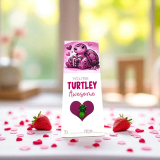 Card with a turtle design and 'You're Turtley Awesome' text on a table with strawberries and confetti.
