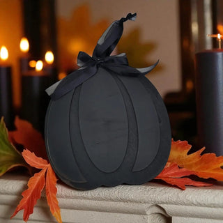 Black decorative pumpkin with a bow on a halloween background