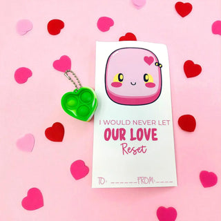 Pink keychain with a card on a pink background with heart shapes