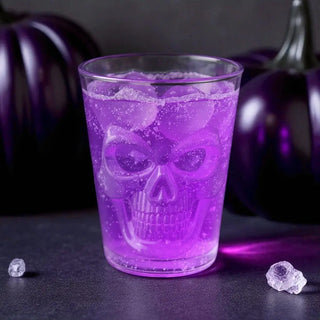 Clear glass filled with purple liquid on a halloween background