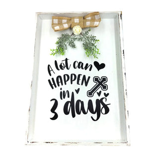 Decorative sign with text 'A lot can happen in 3 days' and decorative elements on a white background