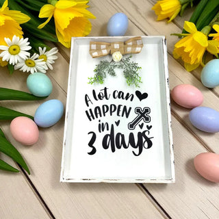 Decorative sign with Easter-themed text and eggs on a wooden surface