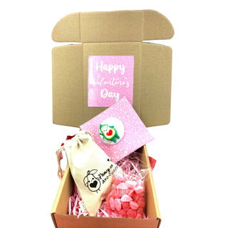 Gift box with 'Happy Valentine's Day' card, pink pouch, and white bag on a white background