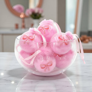 Pink Christmas ornament with a bow on a Christmas tree with lights for a Ballet Nutcracker theme