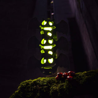 Green glowing bat toy on a dark background