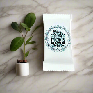 White candy bar with a humorous message on a gray surface with greenery