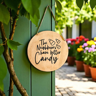 Wooden sign with text hanging on a green door with flowers in the background
