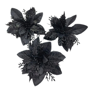 Three black artificial flowers on a white background
