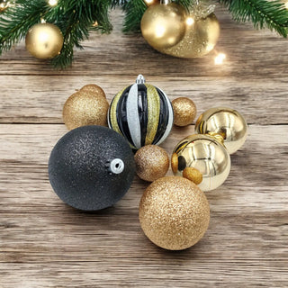 Decorative Christmas ornaments on a wooden surface with greenery.