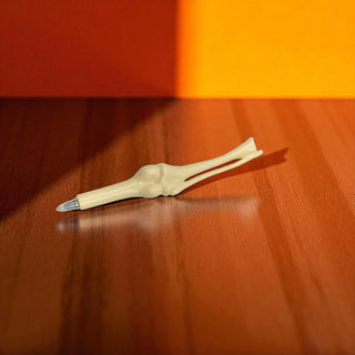 White plastic pen on a wooden surface with an orange background