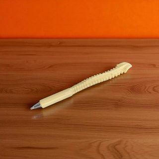 Beige pen on a wooden surface with an orange background