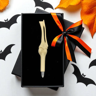 Halloween-themed gift box with a decorative pen on a white background with bats and leaves.