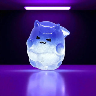 Glowing blue cartoon-like creature on a reflective surface with purple lighting
