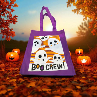Purple tote bag with Halloween design featuring ghosts and 'BOO CREW!' text, set against a scenic background with pumpkins and trees.