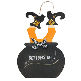 Halloween-themed decoration with witch legs in an oven and 'Bottoms Up' text on a white background