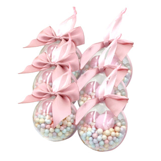 Three clear jars filled with pastel beads and pink bows on a white background