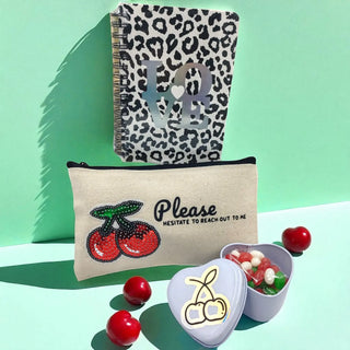Leopard print notebook and pouch with cherry design on a green background