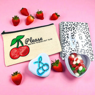 Cherry on Top gift bundle with cherry-themed accessories and gourmet snacks on a pink background