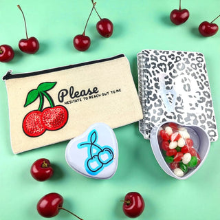 Cherry on Top gift bundle with cherry-themed accessories and gourmet snacks on a green background