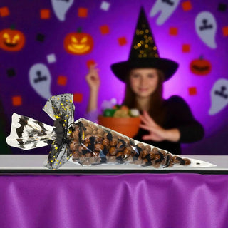 Halloween-themed candy cone with a blurred person in a witch costume in the background.