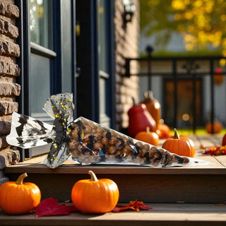Decorative Halloween chocolates with pumpkins and autumn leaves on a windowsill.