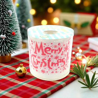 Frosted candle with 'Merry Christmas' text on a festive table setting with Christmas decorations.