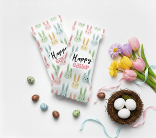 Two 'Happy Easter' eggs with bunny patterns on a white background with Easter decor.