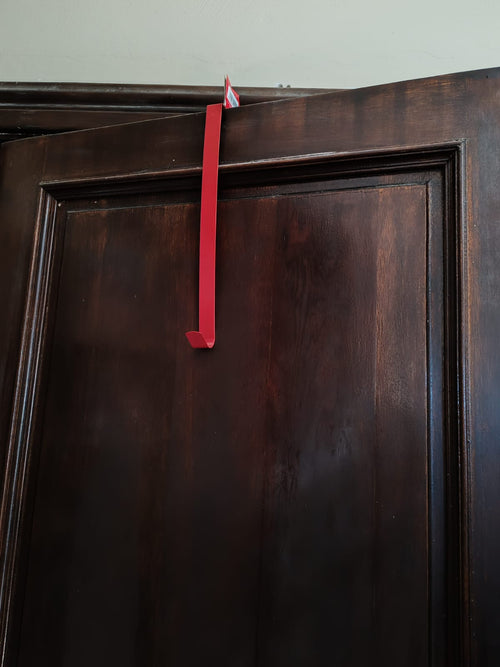 Red strap tied to a wooden cabinet door
