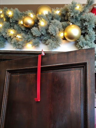 Decorative Christmas garland with gold ornaments and lights on a wooden surface.