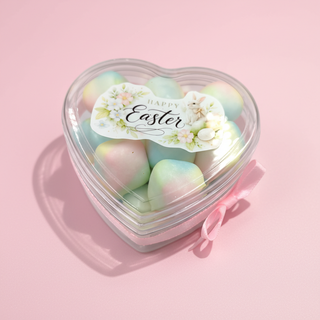 Heart-shaped container of pastel-colored Easter eggs with a 'Happy Easter' label on a pink background.