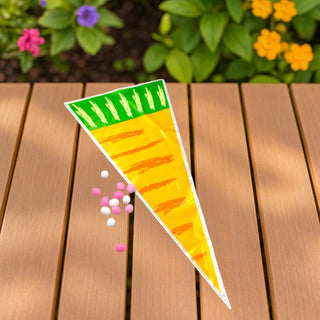 Colorful carrot-shaped product on a wooden surface with flowers in the background
