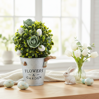 Decorative setup with a potted plant, vase of flowers, and rabbit figurine on a table.
