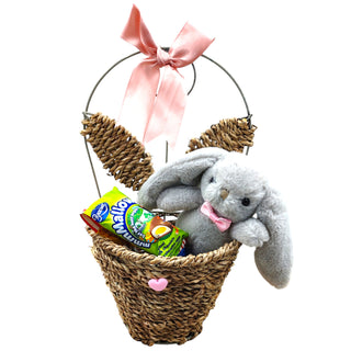 Easter basket with a plush bunny, candy, and a pink bow on a white background