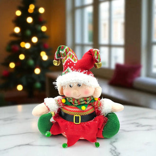 Decorative elf figurine on a marble surface with a blurred Christmas tree in the background